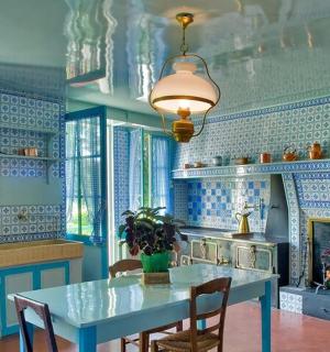 a blue kitchen with a table and a fireplace