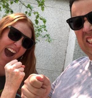 一男一女戴着墨镜，举起双手