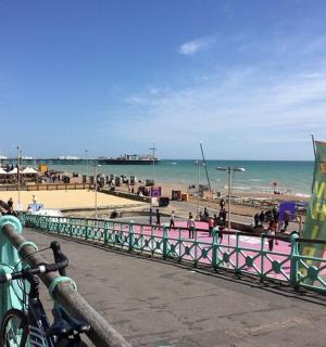 a bike parked next to a fence on a beach