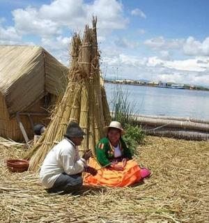 muž a žena sedící na trávě u vody