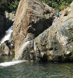 a person standing on a rock near a waterfall