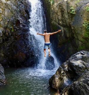 a man is jumping into a waterfall