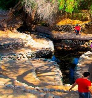 skupina lidí kráčejících po skalách u řeky