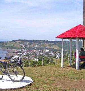 两个人坐在红伞下的长椅上