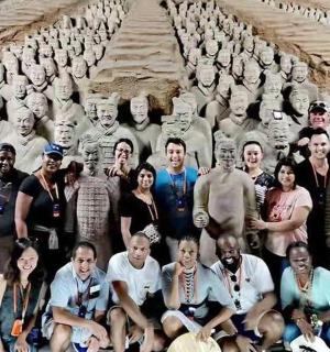 a group of people posing for a picture in front of statues