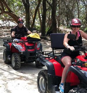 a man and a woman riding atvs on a trail