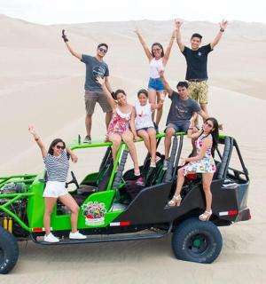 一群人站在沙漠中的一辆四轮车上