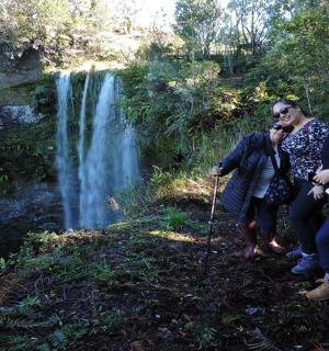 a group of people standing in front of a waterfall