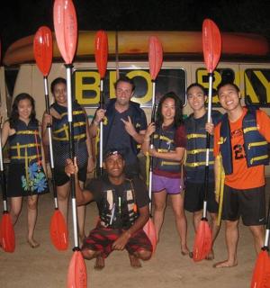 一群人拿着桨站在一辆货车前