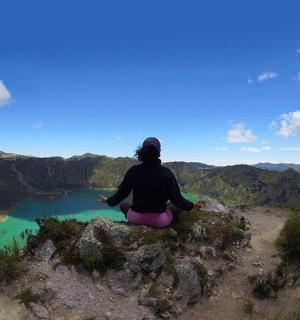 一个人坐在山顶上望着湖