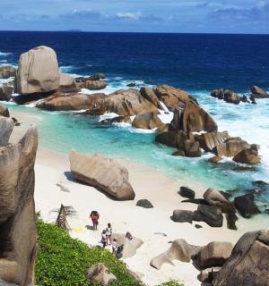 skupina lidí stojících na pláži s kameny