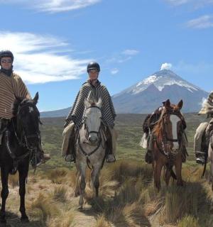tři muži jedoucí na koních s horou v pozadí