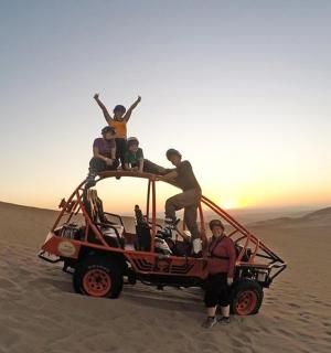 一群人站在沙漠中的一辆吉普车顶上