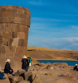 一群人坐在石塔旁的岩石上