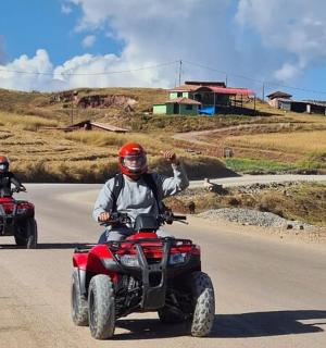 dva lidé na čtyřkolkách jedoucí po silnici