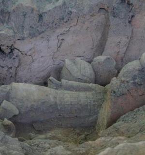 a stone sculpture of a person in a cave