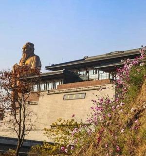 一座坐落在鲜花盛开的建筑物顶上的雕像