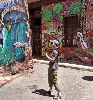 muž stojící před nástěnnou malbou na budově