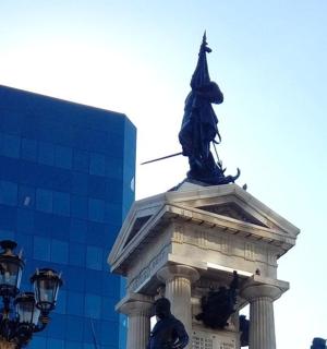 eine Statue auf einem Gebäude mit einer Straßenlaterne