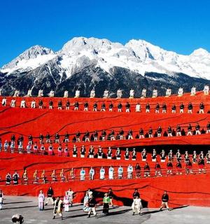 a group of people walking in front of a mountain