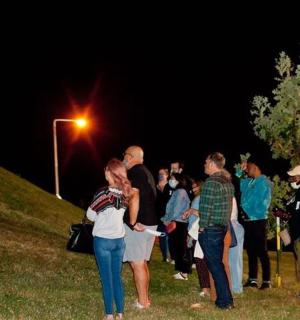 a group of people standing in the grass at night
