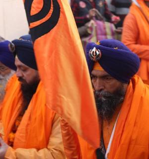 a group of men wearing orange turbans holding a flag
