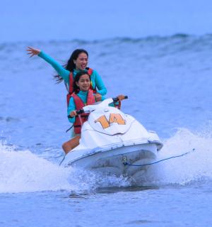 two women riding on a jet ski in the water