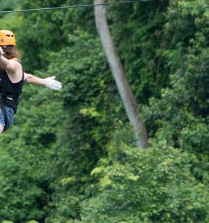 一名女子正悬挂在高空滑索上
