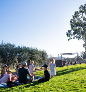 un grup de persones assegudes a l'herba d'un camp