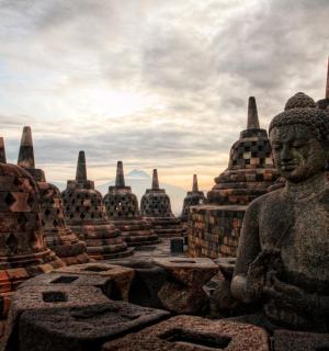 a statue in front of a group of temples