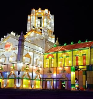 a lit up building with a clock tower at night