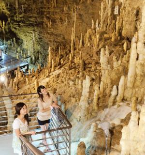 two women in a cave with a rock wall