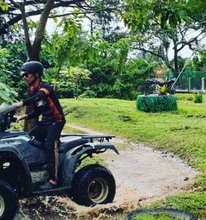 رجل يركب مركبة ذات أربع عجلات على طريق ترابي