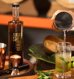 a person pouring a drink into a glass