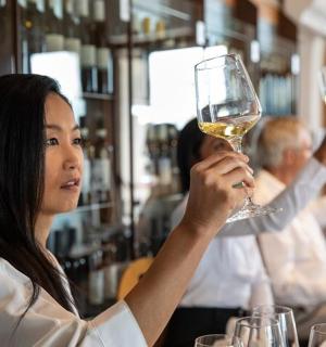 a woman holding a glass of wine in a bar