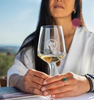 una mujer sosteniendo una copa de vino blanco