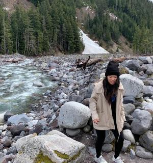 žena stojící na skalách u řeky