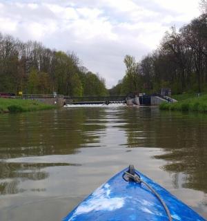 ein blaues Kajak in einem Fluss mit einer Brücke