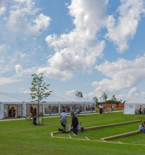 a group of people walking around a park with a monument