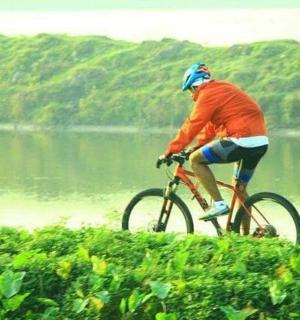 一名男子在湖边的山上骑自行车