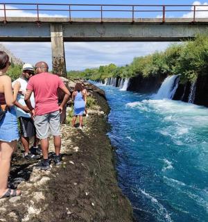 skupina lidí stojící vedle vodopádu