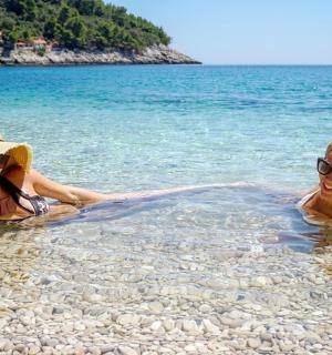 Δύο γυναίκες ξαπλωμένες στο νερό σε μια παραλία