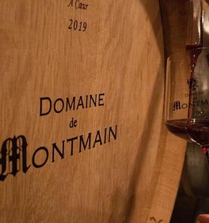 osoba držící sklenici vína vedle krabice od vína