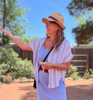 žena v klobouku stojící v zahradě