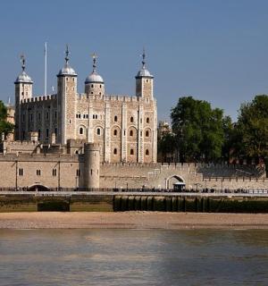 a large stone building next to a body of water