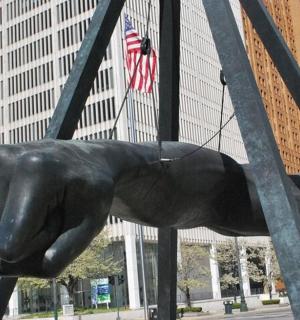 una estàtua d'un gat negre en un carrer de la ciutat