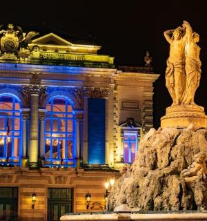 一座带有蓝色灯光的建筑物前的雕像