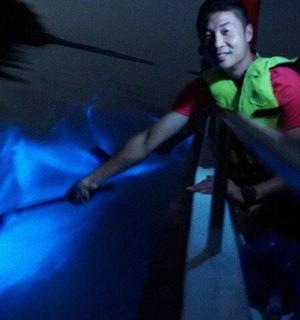 muž stojící v temné místnosti se dvěma netopýry