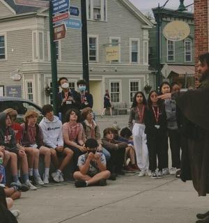 一名男子站在街上，周围是一群人