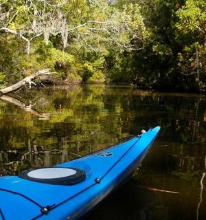 modrý kajak sedící uprostřed řeky